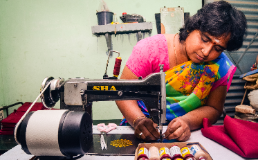 Dhatchayani, a tailor in Tamil Nadu, India, using her sewing machine.