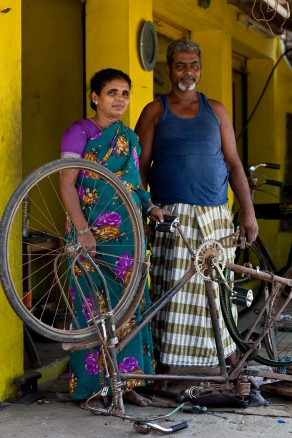 Najma | Bicycle repair shop owner | Tamil Nadu, India. NaJma and husband standing behind a broken bicycle.