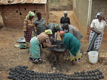 A group of people from a Self Help Group working together to make bricks.