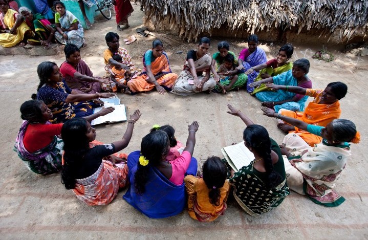 Female members of a Self Help Group in India sitting in a circle.