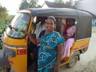 Usha standing outside one of her taxis. 